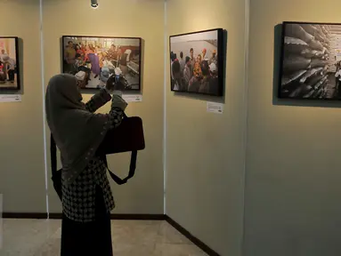 Penunjung melihat pameran foto yang dipamerkan dalam pameran foto Warna-Warni Parlemen di Kompleks Parlemen, Senayan, Jakarta, Senin (29/8). (Liputan6.com/JohanTallo)
