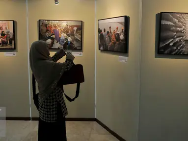 Penunjung melihat pameran foto yang dipamerkan dalam pameran foto Warna-Warni Parlemen di Kompleks Parlemen, Senayan, Jakarta, Senin (29/8). (Liputan6.com/JohanTallo)