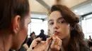Model saat didandani di belakang panggung sebelum tampil di atas catwalk mengenakan busana Preen karya Thornton Bregazzi pada Autumn / Winter 2017 London Fashion Week di London, Inggris (19/2).  (AFP Photo / Niklas Halle'n) 