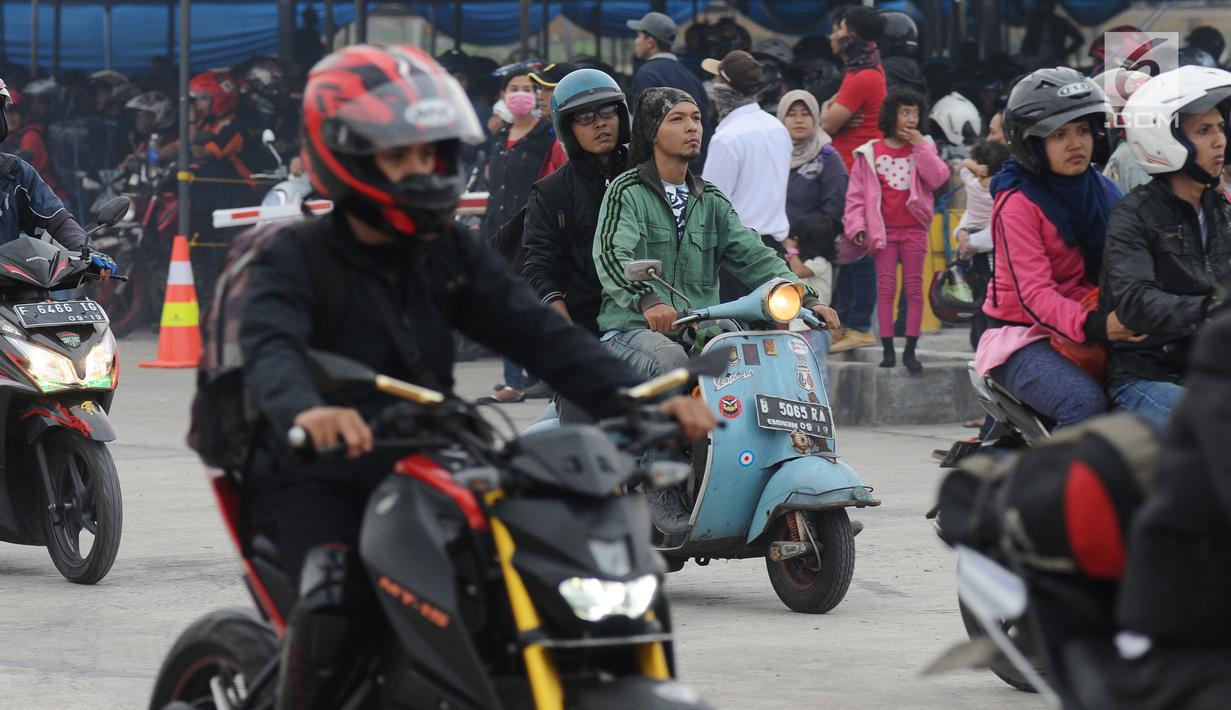 Pemudik menggunakan Vespa keluaran tahun 60 an saat masuk ke dalam kapal penyeberangan di Pelabuhan Merak, Banten, Jumat (23/6). H-2 Lebaran 2017, ribuan pemudik bermotor memadati dermaga 6 Pelabuhan Banten. (Liputan6.com/Helmi Fithriansyah)