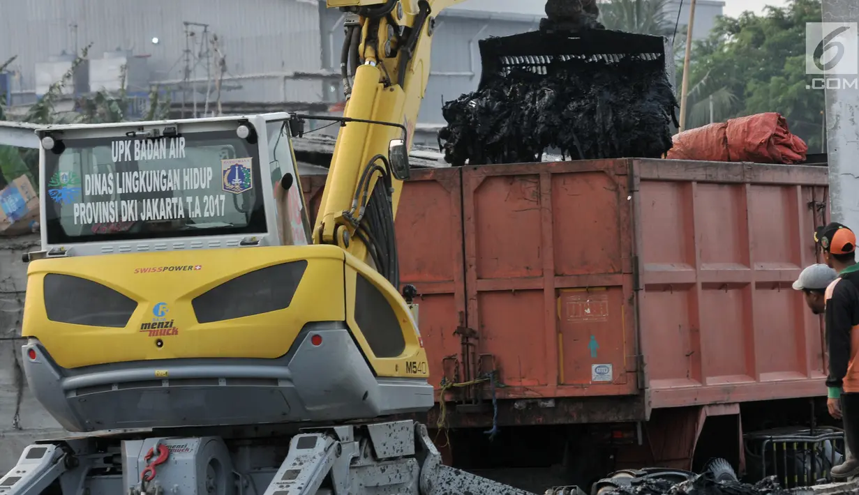 Petugas UPK Badan Air Dinas Lingkungan Hidup DKI Jakarta menggunakan alat berat membersihkan sampah di Kampung Bengek, Muara Baru, Penjaringan, Jakarta, Rabu (4/9/2019). Setelah viral, lautan sampah yang memenuhi tanah garapan milik PT Pelindo II itu mulai dibersihkan. (merdeka.com/Iqbal Nugroho)