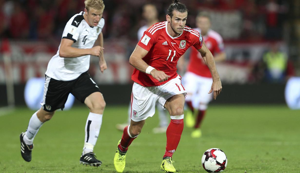 Pemain Wales, Gareth Bale melewati adangan pemain Austria pada laga Group D kualifikasi Piala Dunia 2018 di Cardiff City Stadium, Cardiff, (2/8/2017). Wales menang 1-0. (David Davies/PA via AP)