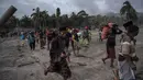 Warga menyelamatkan barang-barang saat abu vulkanik erupsi Gunung Semeru menutupi Desa Sumber Wuluh, Lumajang, Jawa Timur, 5 Desember 2021. Erupsi Gunung Semeru terjadi pada Sabtu, 4 Desember 2021. (JUNI KRISWANTO/AFP)