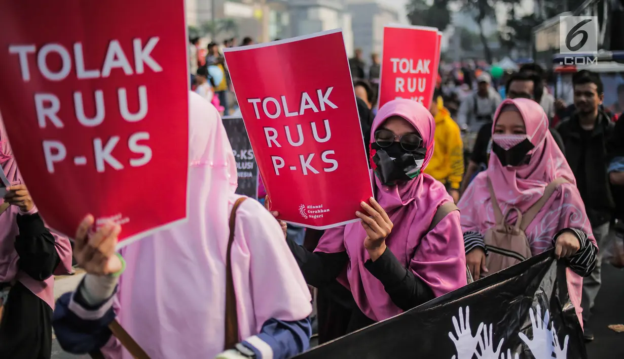 Aktivis Aliansi Gerakan Peduli Perempuan membawa spanduk berisi penolakan terhadap Rancangan Undang-Undang Penghapusan Kekerasan Seksual (RUU PKS) saat car free day di kawasan Bundaran HI, Jakarta, Minggu (14/7/2019). Mereka menolak rencana pengesahan RUU PKS. (Liputan6.com/Faizal Fanani)