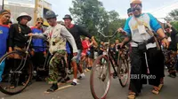 Anggota komunitas pesepeda beradu cepat menggunakan bakiak sambil menuntun sepeda pada Pencanangan Kota Solo Nyaman untuk Pesepeda di kawasan Ngarsopuro, Solo, Minggu (25/2/2018). (Nicolous Irawan/JIBI/SOLOPOS)