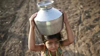 Seorang anak membawa kendi berisi air di Latur, India, (17/4). Akibat bencana kekeringan warga mengalami krisis air bersih yang melanda India. (REUTERS/Danish Siddiqui)