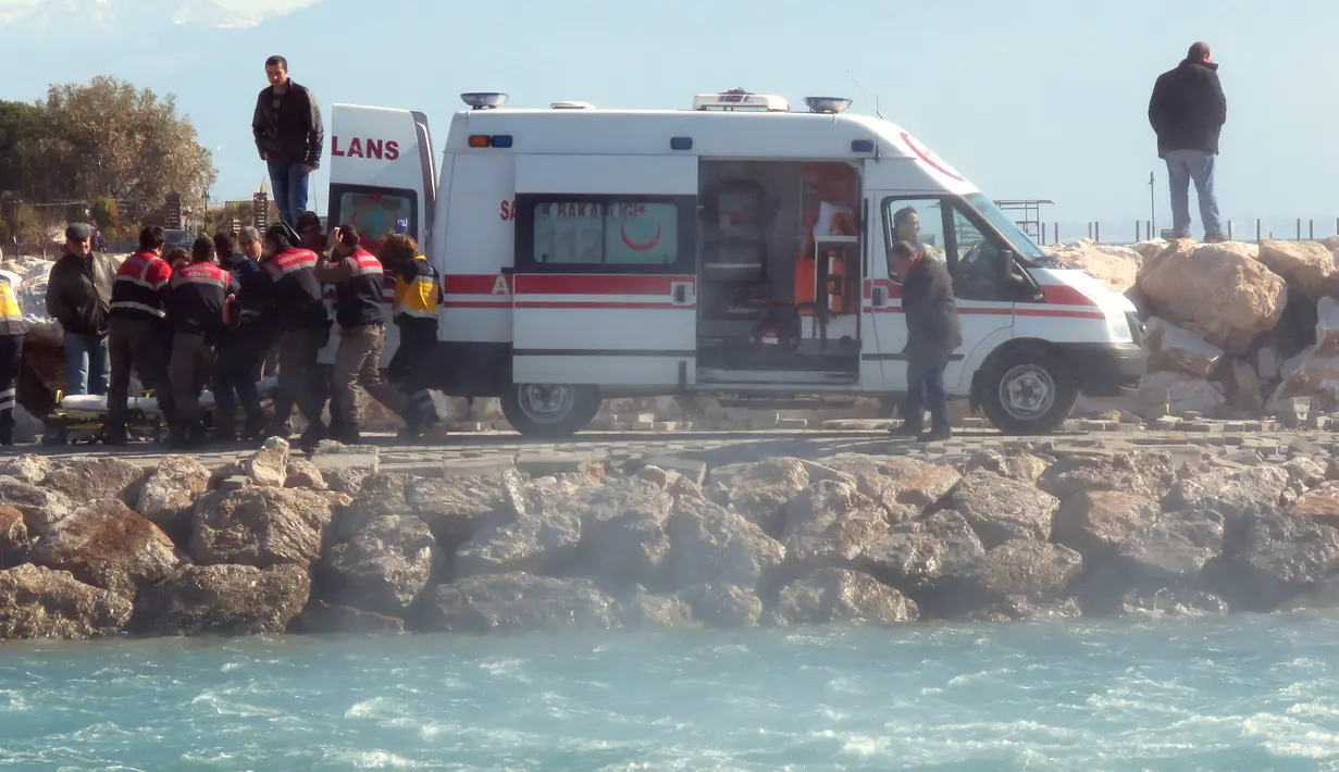 Petugas memasukkan korban tenggelam para imigran di distrik Altinoluk, Balikesir, Turki, (8/2). Diduga tenggelamnya perahu mereka karena sebuah kecelakaan. (STR / AFP)