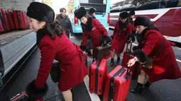 Tim pemandu sorak Korea Utara memasukan koper ke dalam bus saat tiba kantor transit Korea di dekat Zona Demiliterisasi di Paju, Korea Selatan, (7/2). (AP Photo/Ahn Young-joon. Pool)