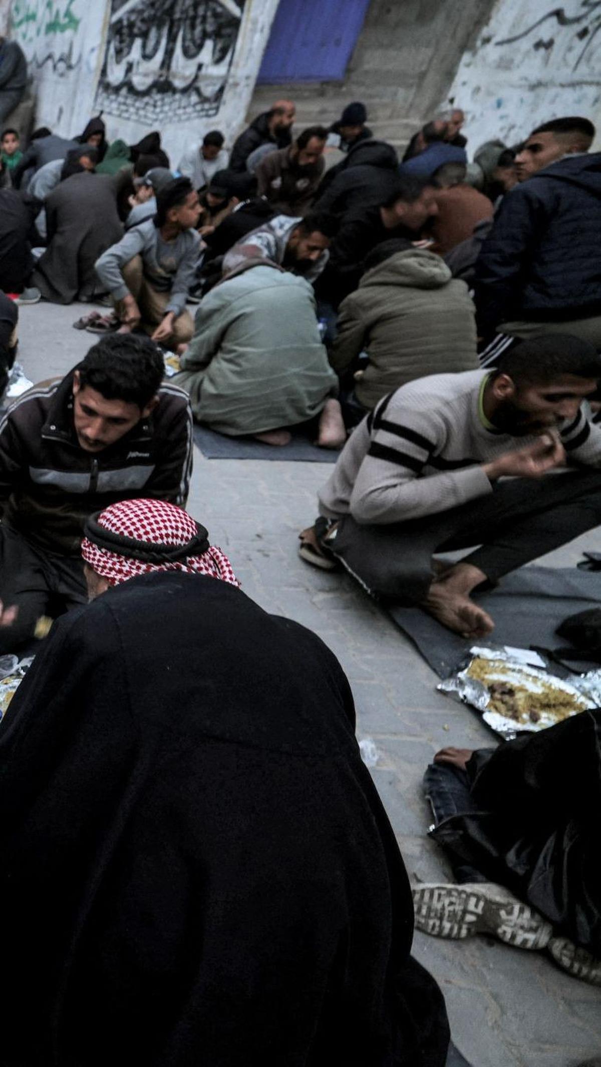 Selama acara berlangsung, suasana terlihat penuh dengan kegembiraan. Hal itu dapat dilihat dari wajah-wajah warga Gaza yang menikmati hidangan buka puasa yang disediakan.&nbsp;Foto: MOHAMMED ABED / AFP