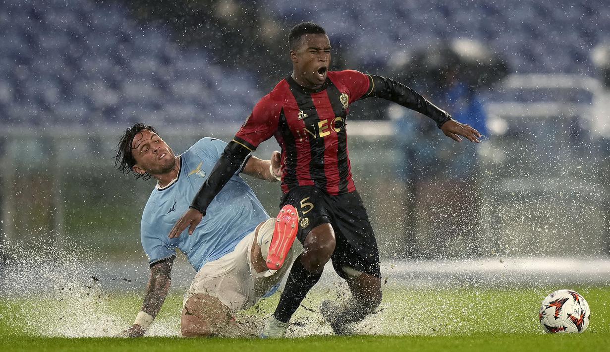 Pemain Lazio, Luca Pellegrini (kiri) berebut bola dengan pemain Nice, Youssoufa Moukoko pada laga Liga Europa 2024/2025 yang berlangsung di Olympic Stadium, Roma, Italia, Jumat (04/10/2024) dini hari WIB. (AP Photo/Andrew Medichini)