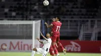 Pemain Timnas Indonesia U-20, Frengky Missa berebut bola di udara dengan pemain Timnas Timor Leste U-20 dalam laga pertama Grup F Kualifikasi Piala Asia U-20 2023 di Stadion Gelora Bung Tomo, Surabaya (14/9/2022). (Bola.com/Ikhwan Yanuar)