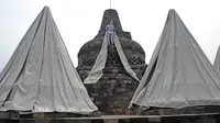 Seorang pekerja menutup stupa di kompleks candi Borobudur, Magelang, Jawa Tengah, Senin (23/11/2020). Penutupan candi Borobudur oleh BKB (Balai Konservasi Borobudur) sebagai langkah antisipasi melindungi batu candi dari abu vulkanik jika Gunung Merapi erupsi. (Photo by Agung Supriyanto/AFP)