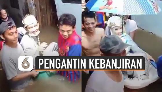 VIDEO: Penuh Perjuangan, Sepasang Pengantin Digotong Pakai Bak Bayi Saat Banjir