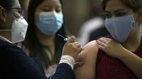 Seorang wanita muda menerima dosis pertama vaksin AstraZeneca di Mexico City, saat Meksiko menghadapi gelombang ketiga COVID-19, Selasa (10/8/2021). Hampir seperempat dari negara Meksiko berada dalam kondisi siaga merah karena infeksi Covid-19 naik ke level tertinggi. (ALFREDO ESTRELLA/AFP)
