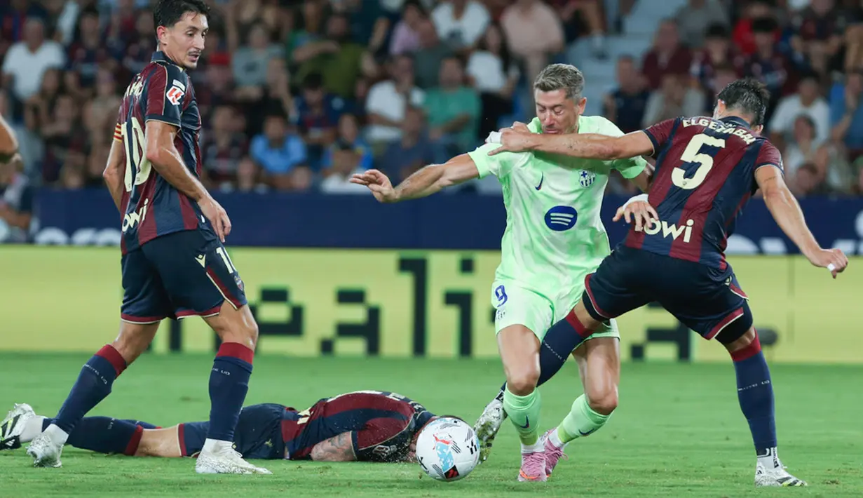 Pemain Barcelona, Robert Lewandowski, berusaha melewati pemain Levante pada jornada kedua La Liga 2025/2026 di Estadio Ciudad de Valencia, Minggu (24/8/2025) dini hari WIB. (AP Photo/Alberto Saiz)