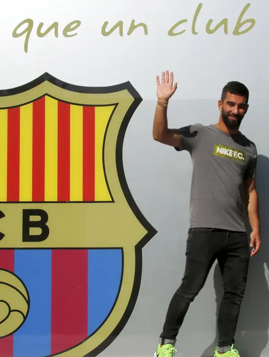 Pemain baru Barcelona, Arda Turan tersenyum menyapa awak media saat sesi perkenalan di luar Stadion Camp Nou, Barcelona, Spanyol, (9/7/2015). Arda Turan harus menunggu hingga akhir 2015 untuk dapat bermain dengan Barcelona. (REUTERS/Gustau Nacarino)