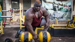 Iron Biby melakukan latihan di rumahnya di Bobo-Dioulasso, Burkina Faso pada 24 September 2018. April lalu, pria dengan berat badan 180 kg itu memenangkan kejuaraan dunia mengangkat batangan kayu seberat 230 kg. (OLYMPIA DE MAISMONT / AFP)