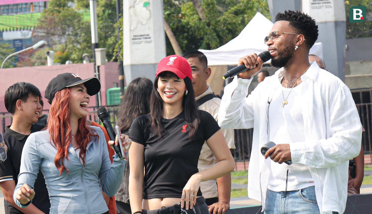 Daniel Sturridge (kanan) bercanda dengan para pembawa acara pada acara Second Chance yang berkolabolasi dengan EA FC Mobile di Plaza dan Stadion Patriot Candrabhaga, Kota Bekasi, Minggu (29/3/2026) pagi. (Bola.com/Abdul Aziz)