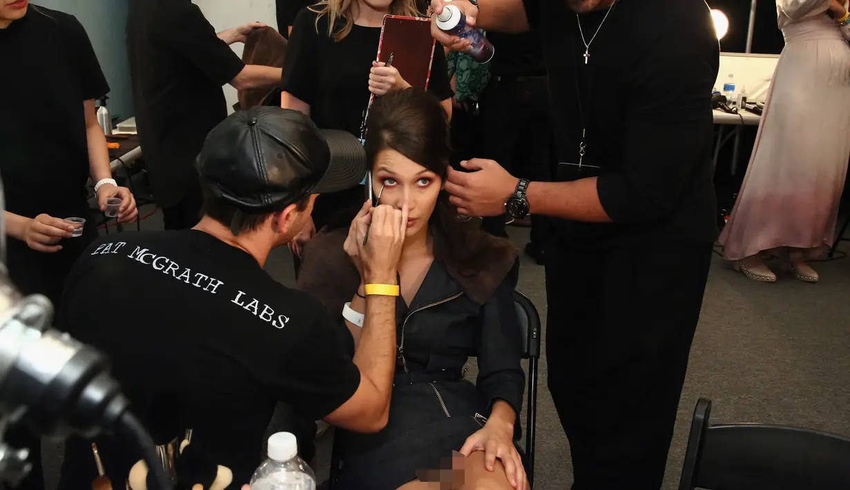 Bella Hadid saat dirias matanya di belakang panggung fashion show Anna Sui selama New York Fashion Week, AS (14/9). Adik dari Gigi Hadid ini terlihat cantik.  (AFP Photo/Astrid Stawiarz