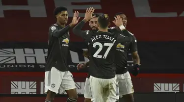 Penyerang Manchester United, Marcus Rashford (kiri) berselebrasi dengan rekannya usai mencetak gol ke gawang Sheffield United pada pertandingan Liga Inggris di stadion Bramall Lane di Sheffield, Inggris, Jumat (18/12/2020). Rashford mencetak dua gol dan mengantar MU menang 3-2. (AP Photo/Rui Vieira)