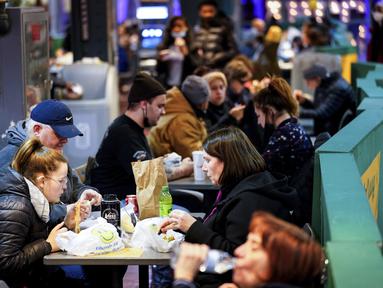 Pelanggan makan di Reading Terminal Market di Philadelphia, Rabu (16/2/2022). Pejabat kota Philadelphia mencabut mandat vaksin untuk makan di dalam ruangan dan tempat lain yang menyajikan makanan dan minuman, tetapi mandat masker dalam ruangan tetap berlaku. (AP Photo/Matt Rourke)