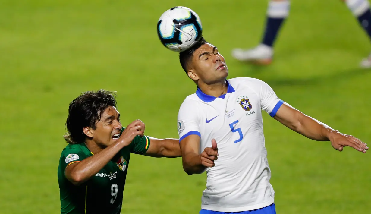 Gelandang Brasil, Casemiro (kanan) berebut bola udara dengan pemain Bolivia, Marcelo Martins Moreno selama pertandingan grup A Piala Copa America 2019 di stadion Morumbi di Sao Paulo, Brasil (14/6/2019). Brasil menang telak 3-0 atas Bolivia. (AP Photo/Nelson Antoine)
