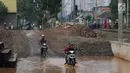 Pengendara motor melintasi genangan air di kawasan Kemiri Muka, Depok, Jawa Barat, Senin (2/10). Buruknya sistem drainase menyebabkan air selalu menggenang setiap musim hujan sehingga mengganggu aktivitas warga. (Liputan6.com/Immanuel Antonius)