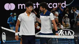 Petenis Korea Selatan Chung Hyeon berbincang usai mengalahkan petenis Serbia, Novak Djokovic pada putaran keempat kejuaraan tenis Australia Terbuka di Melbourne (22/1). Chung Hyeon menang 6-7(4), 5-7, 6-7(3). (AFP Photo/Paul Crock)