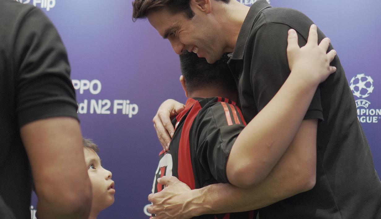 <p>Legenda timnas Brasil dan AC Milan, Kaka, memeluk seorang penggemar cilik yang memakai jersey I Rossoneri di Jakarta pada Sabtu (3/6/2023) malam hari WIB. (Bola.com/Okie Prabhowo)</p>