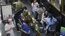 Pengunjung mengenakan masker mengobrol di restoran yang dibuka kembali di pusat perbelanjaan di Beijing, Senin (6/6/2022). Pengunjung kembali ke restoran di sebagian besar Beijing untuk pertama kalinya dalam lebih dari sebulan sebagai pihak berwenang lebih lanjut melonggarkan pembatasan terkait pandemi wabah COVID-19. (AP Photo/Andy Wong)