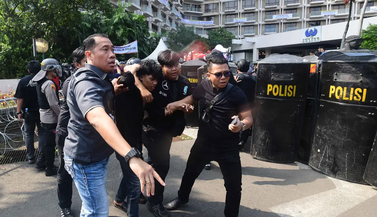 Petugas menangkap salah satu massa yang menolak eksekusi lahan Hotel Sultan saat bentrok dengan aparat pengamanan gabungan di kawasan Gelora Bung Karno (GBK), Jakarta, Kamis (18/6/2026). (merdeka.com/Arie Basuki)