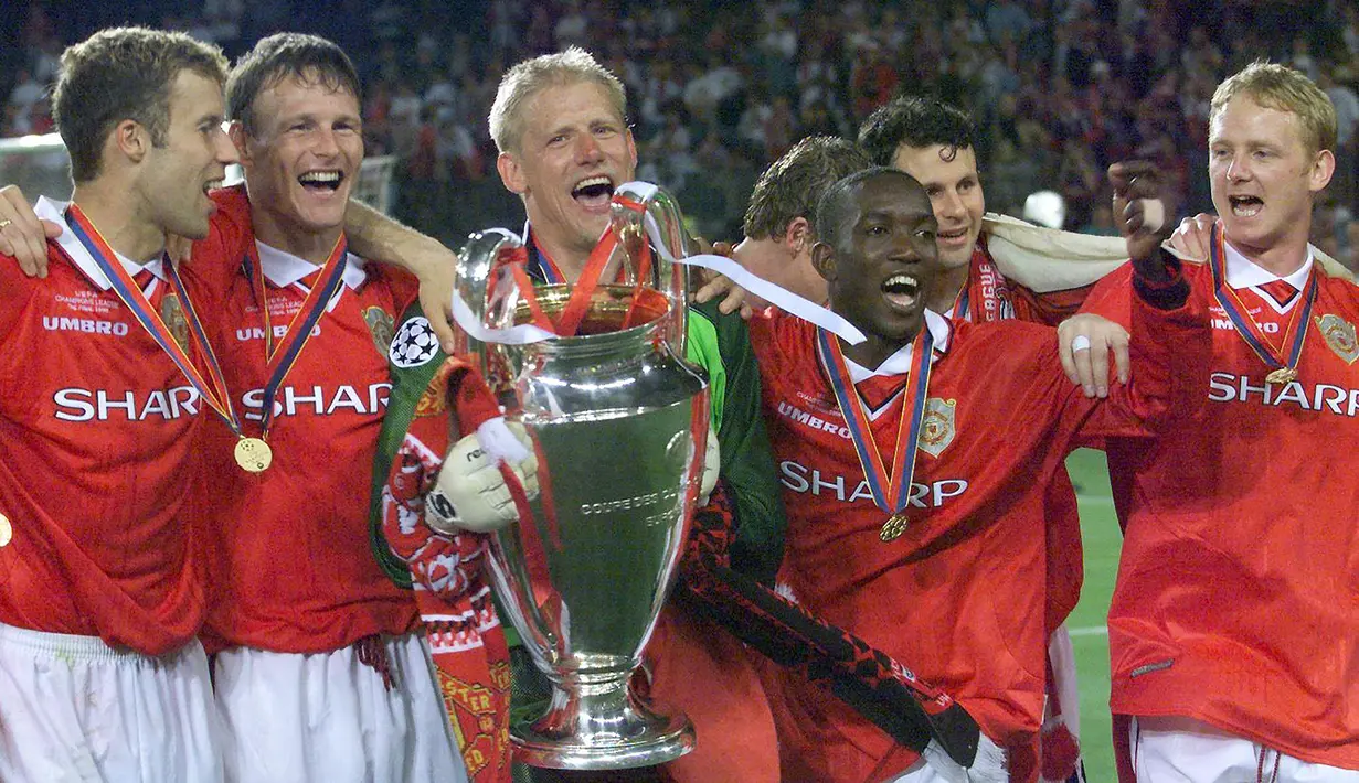 Selebrasi para pemain Manchester United dengan trofi juara setelah mengalahkan Bayern Munchen pada laga final Liga Champions 1998/1999 di Camp Nou Stadium, Barcelona (26/5/1999). Pada laga tersebut Bayern Munchen kalah 1-2 setelah sempat unggul 1-0 hingga injury time. (AFP/Eric Cabanis)