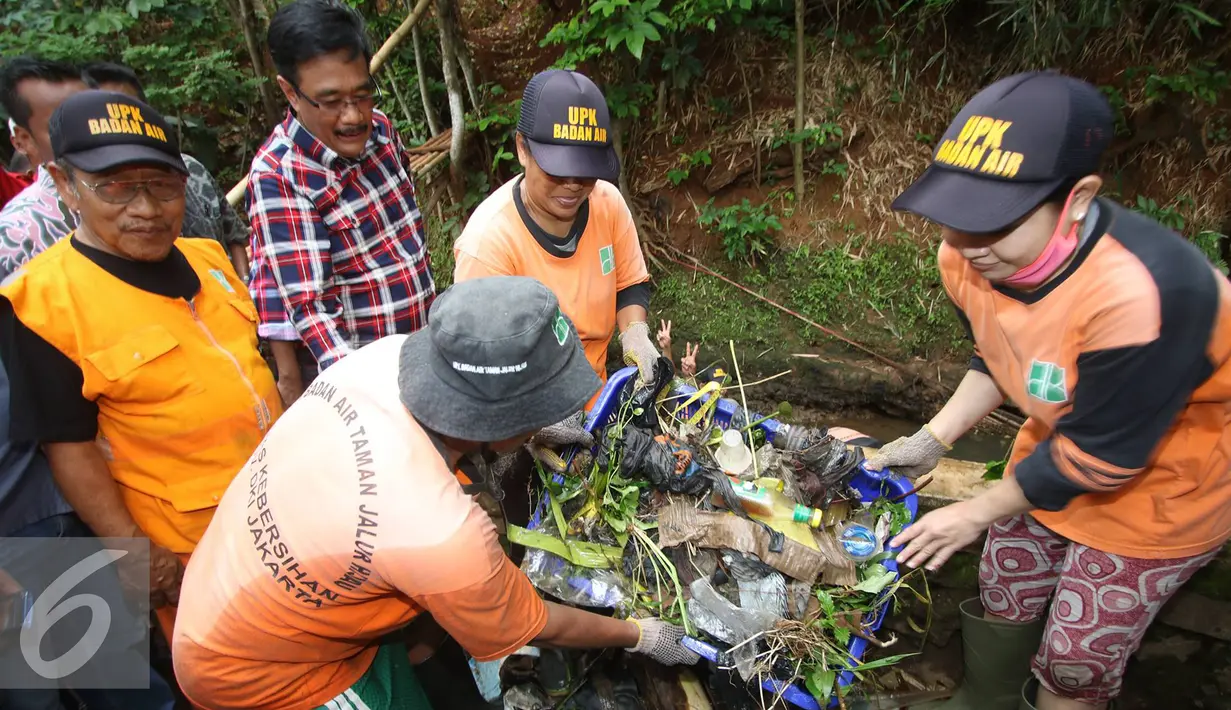 Djarot Saiful Hidayat memperhatikan petugas kebersihan yang sedang bekerja mengangkat sampah disaluran air di kawasan Pasar Rebo, Jakarta Timur, Rabu (2/11). (Liputan6.com/Immanuel Antonius)