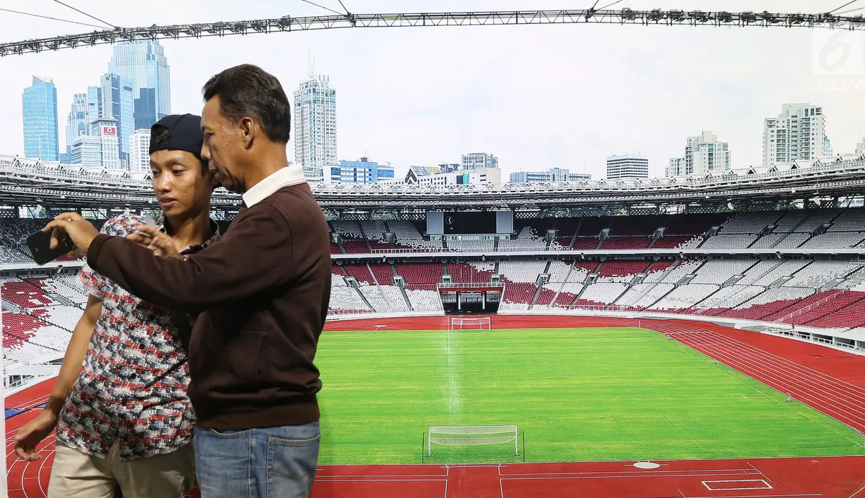 Pengunjung melihat hasil foto berlatar Stadion Utama Gelora Bung Karno yang dipamerkan di area Stadion GBK, Jakarta, Rabu (29/8). Sejumlah dokumentasi pembangunan stadion dicetak dan bisa dilihat warga. (Liputan6.com/Helmi Fithriansyah)