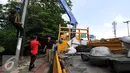 Pekerja usai mencopot lampu dan mengganti tiang lampu PJU di Jakarta, Selasa (29/12). Pemrov DKI Jakarta akan mengganti seluruh lampu listrik Penerangan Jalan Umum (PJU) dari konvensional menjadi lampu hemat energi LED. (Liputan6.com/Yoppy Renato)