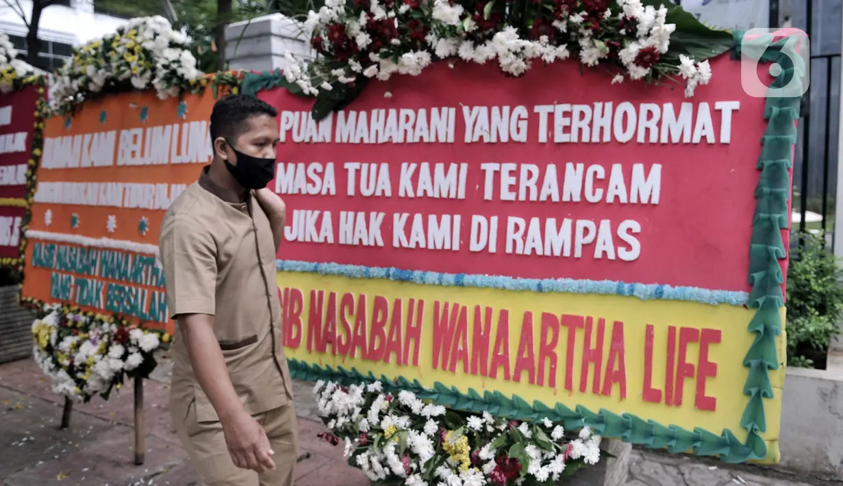 Warga berjalan dekat karangan bunga dari korban asuransi Jiwasraya yang terpajang di depan Gedung Pengadilan Tipikor, Jakarta, Rabu (3/6/2020). Puluhan karangan bunga tersebut berisi harapan para korban agar kasus segera tuntas dan uang mereka dapat kembali. (merdeka.com/Iqbal S. Nugroho)