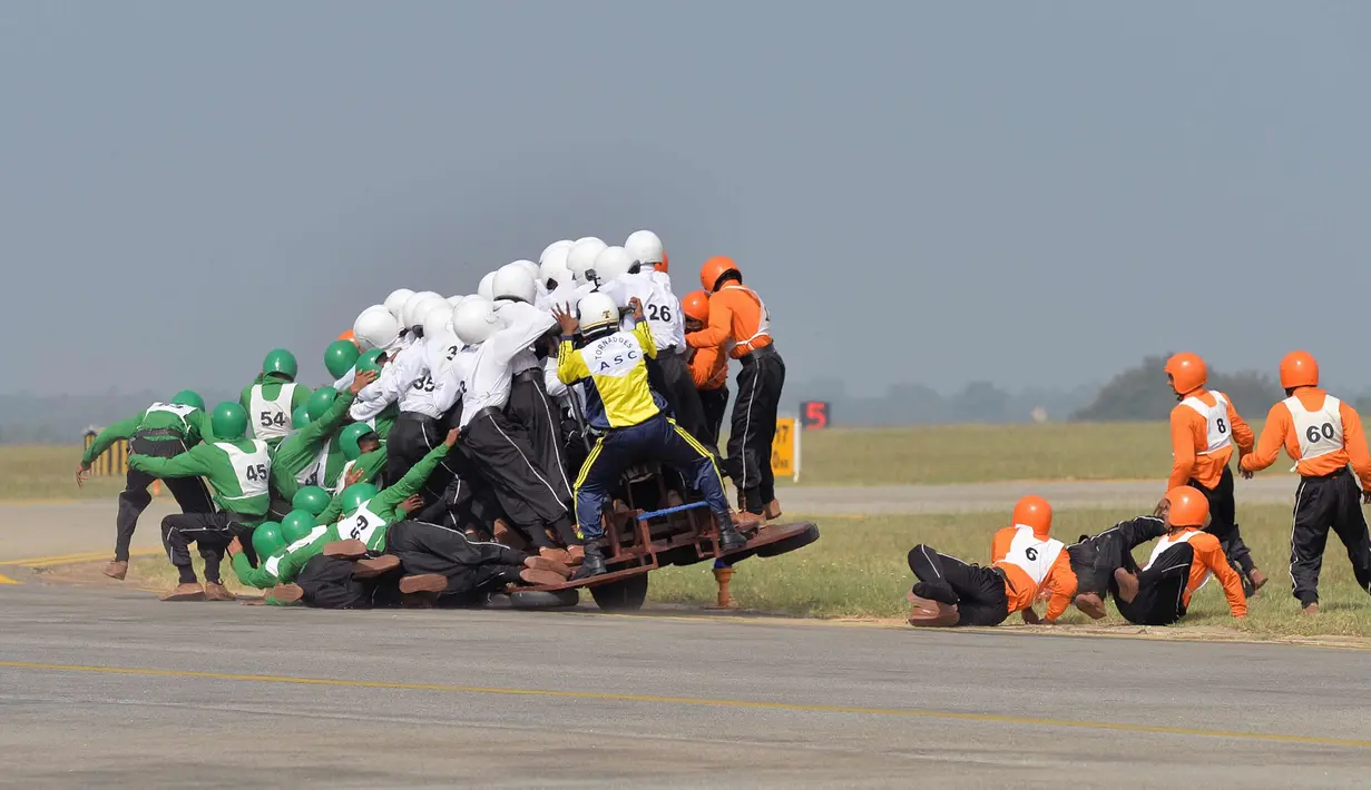 Tim Tornado dari Army Service Corps (ASC) terjatuh saat memecahkan rekor dunia membawa 58 orang dengan satu motor 500 cc di Bangalore (19/11). Tim Tornado menciptakan rekor dunia baru setelah 58 orang naik satu motor 500 cc. (AFP Photo/Manjunath Kiran)