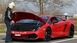 Sonja Heiniger, nenek berusia 76 tahun, ketika melakukan pengecekan terhadap mesin Lamborghininya di Jona, Swiss (20/5/2015). (REUTERS/Alessandro Garofalo)