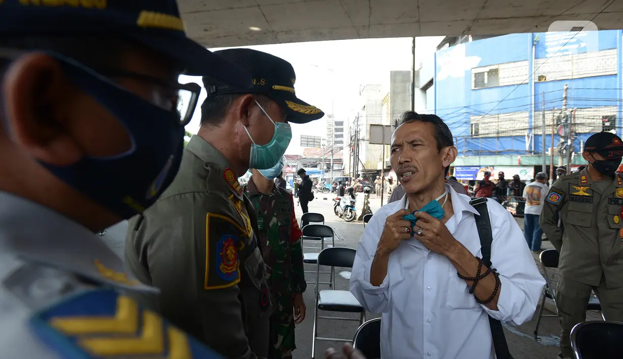 Petugas Satpol PP mengimbau warga menggunakan masker saat Operasi Yustisi Protokol Kesehatan Covid-19 di Terminal Kampung Melayu, Jakarta, Kamis (24/9/2020). Operasi untuk menegakkan disiplin dalam penerapan protokol kesehatan itu melibatkan Organisasi Kemasyarakatan. (merdeka.com/Imam Buhori)