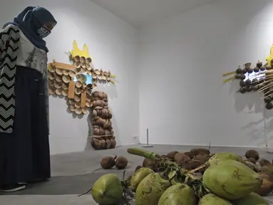 Pengunjung melihat karya yang dipajang dalam pameran Pulih di Pasar Seni, Ancol, Jakarta, Sabtu (14/11/20). Pameran PULIH ini merupakan pameran pertama dalam program revitalisasi Pasar Seni Ancol selama masa pandemi. (Liputan6.com/Herman Zakharia)