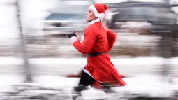 Seorang wanita berpakaian Sinterklas mengambil bagian dalam Santa Claus Run di Pristina, Kosovo, Minggu (16/12). Ratusan pelari berpartisipasi dalam lomba lari amal untuk menggalang dana bagi keluarga yang membutuhkan di Kosovo. (Armend NIMANI/AFP)