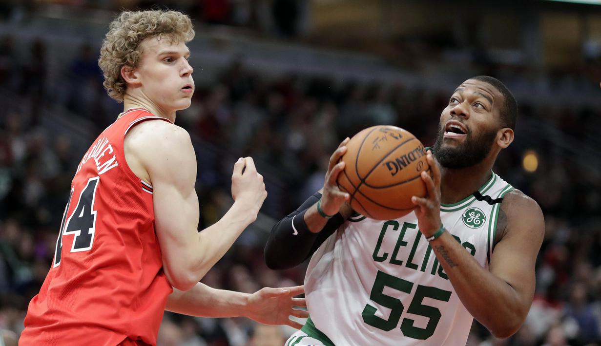 Pebasket Chicago Bulls, Lauri Markkanen, berusaha melewati pebasket Boston Celtics, Greg Monroe, pada laga NBA di Stadion United Center, Selasa (6/3/2018). Celtics menang 105-89 atas Bulls. (AP/Charles Rex Arbogast)