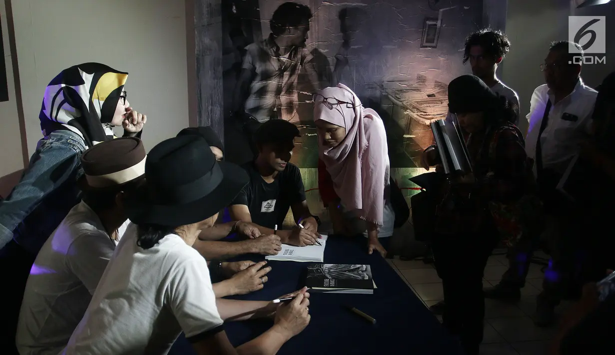 Para pengunjung meminta tanda tangan seusai pembukaan pameran foto dan peluncuran buku "Tanpa Batas" bersama #KLYLOUNGE di Jakarta, Jumat (14/12). Fotografer Tjandra Moh Amin meluncurkan buku Tanpa Batas Slank. (Liputan6.com/Herman Zakharia)