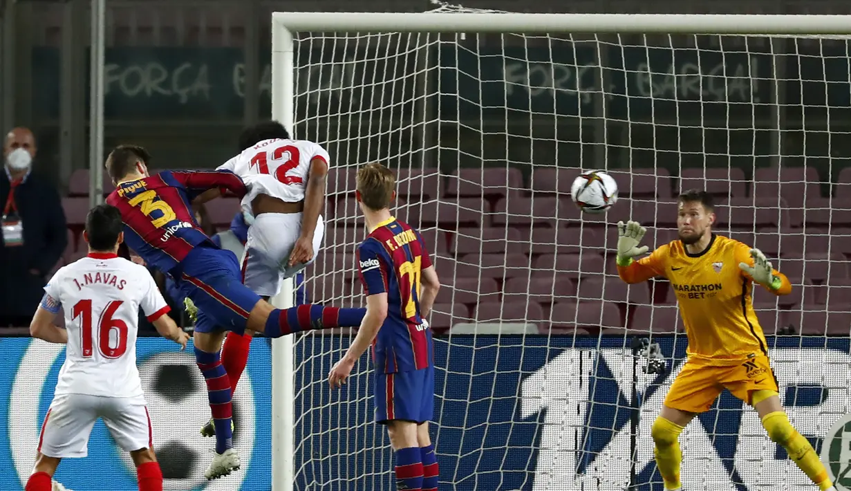 Bek Barcelona, Gerard Pique (kedua dari kiri) melepaskan sundulan yang berbuah gol kedua timnya ke gawang Sevilla dalam laga leg kedua semifinal Copa Del Rey 2020/21 di Camp Nou Stadium, Rabu (3/3/2021). Barcelona menang 3-0 melalui extra time dan lolos ke babak final. (AP/Joan Monfort)