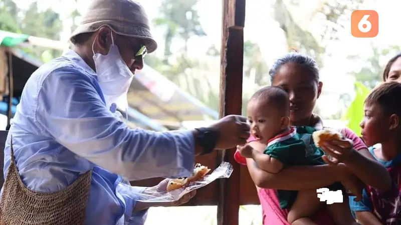 Bupati Bonebol saat memberikan makan kepada balita yang ada di lokasi tambang emas ilegal Suwawa (Arfandi Ibrahim/Liputan6.com)