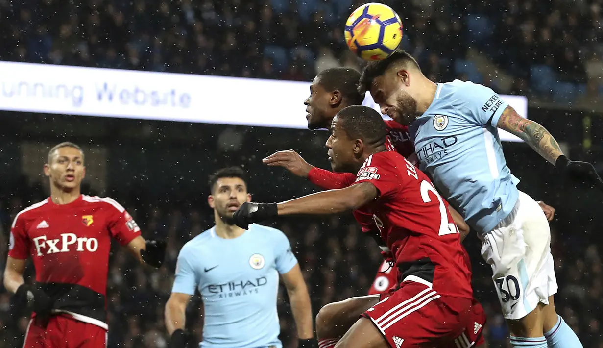 Aksi pemain Manchester City, Nicolas Otamendi menghalau bola dari dua pemain Watford pada lanjutan Premier League di Etihad stadium, Manchester, (2/1/2018).  City menang 3-1. (Martin Rickett/PA via AP)