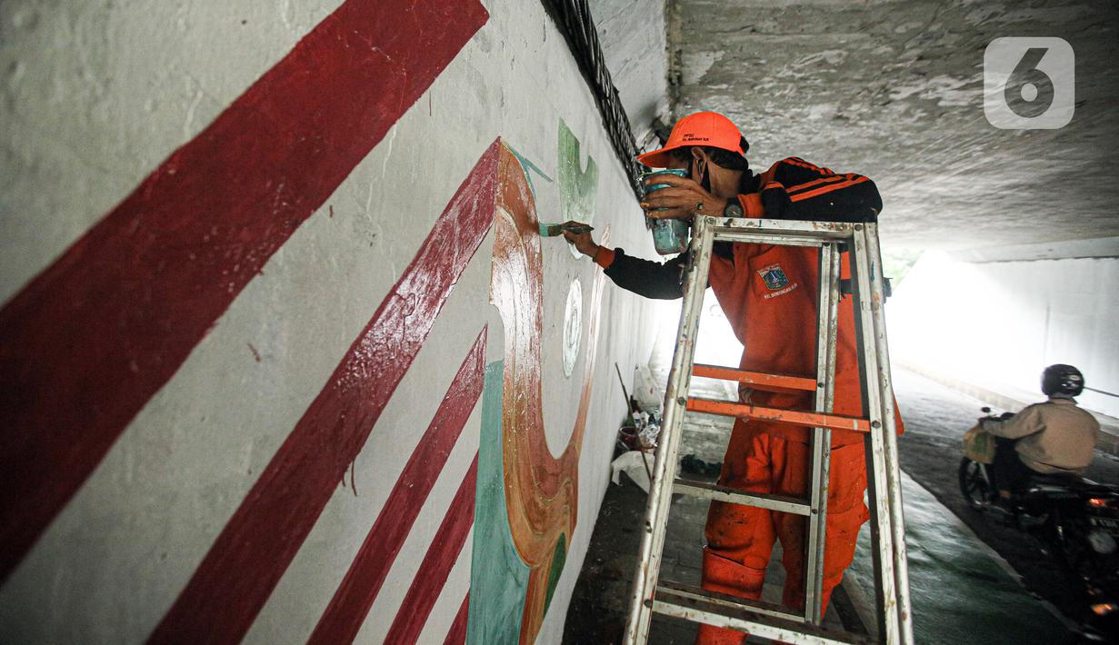 Seorang petugas PPSU menaiki tangga saat melukis mural pada tembok kolong Semanggi. (Liputan6.com/Faizal Fanani)