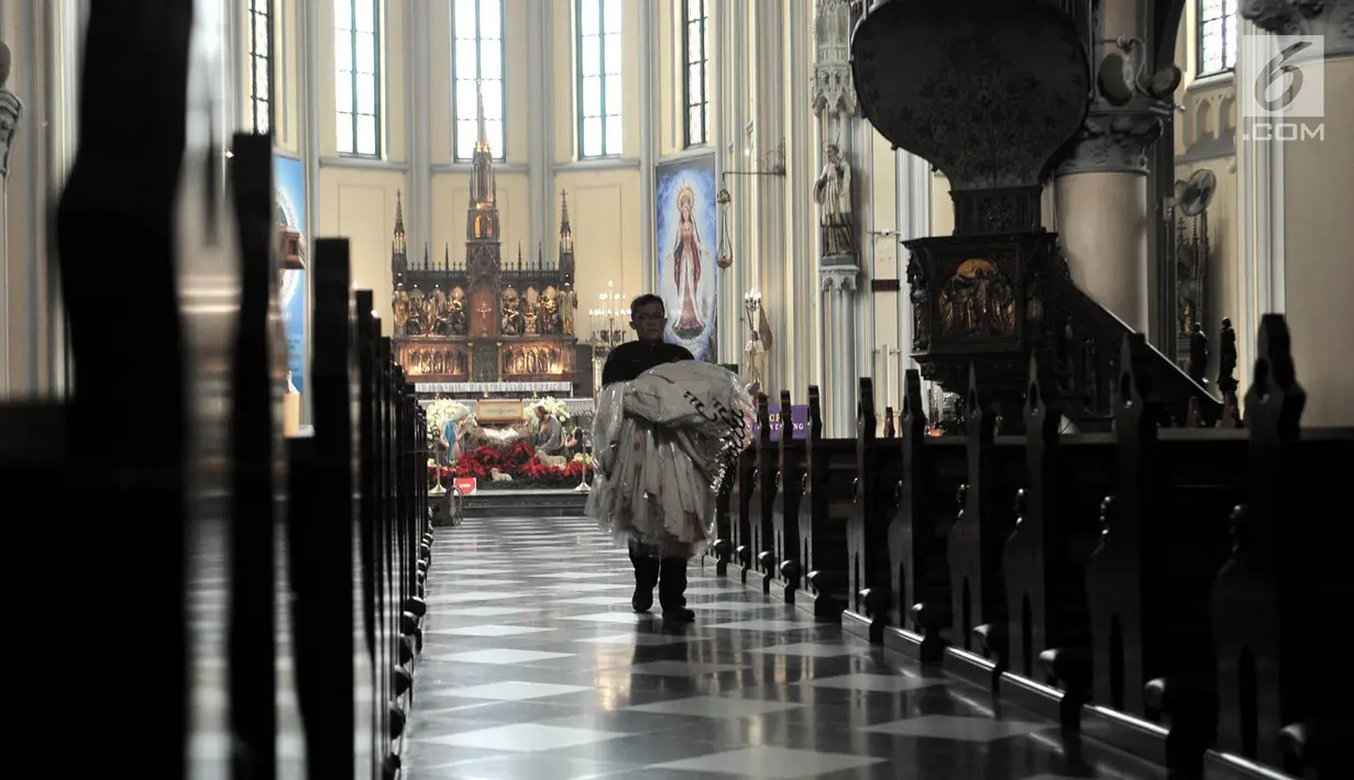 Pantia membawa pakaian pendeta untuk persiapan menyambut perayaan Hari Natal di Gereja Katedral, Jakarta, Minggu (23/12). Gereja Katedral mengusung tema 'Persatuan Indonesia' dalam perayaan Natal tahun ini. (Merdeka.com/Iqbal S Nugroho)