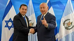 Presiden Guatemala Jimmy Morales (kiri) foto bersama PM Israel Benjamin Netanyahu di Yerusalem, Rabu (16/5). Langkah Guatemala memindahkan Kedubesnya ke Yerusalem dilakukan dua hari setelah AS melakukan hal serupa. (Debbie Hill/Pool Photo via AP)