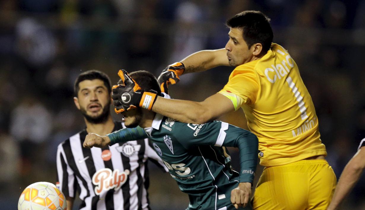 Pemain Santiago Wanderers, Carlos Gonzalez (tengah) berebut bola dengan Rodrigo Munoz (kanan) dan Pedro Benitez dari klub Libertad dalam pertandingan Copa Sudamericana di Stadion Nicolas Leoz, Asuncion, Paraguay. (18/8/2015). (Reuters/Jorge Adorno)